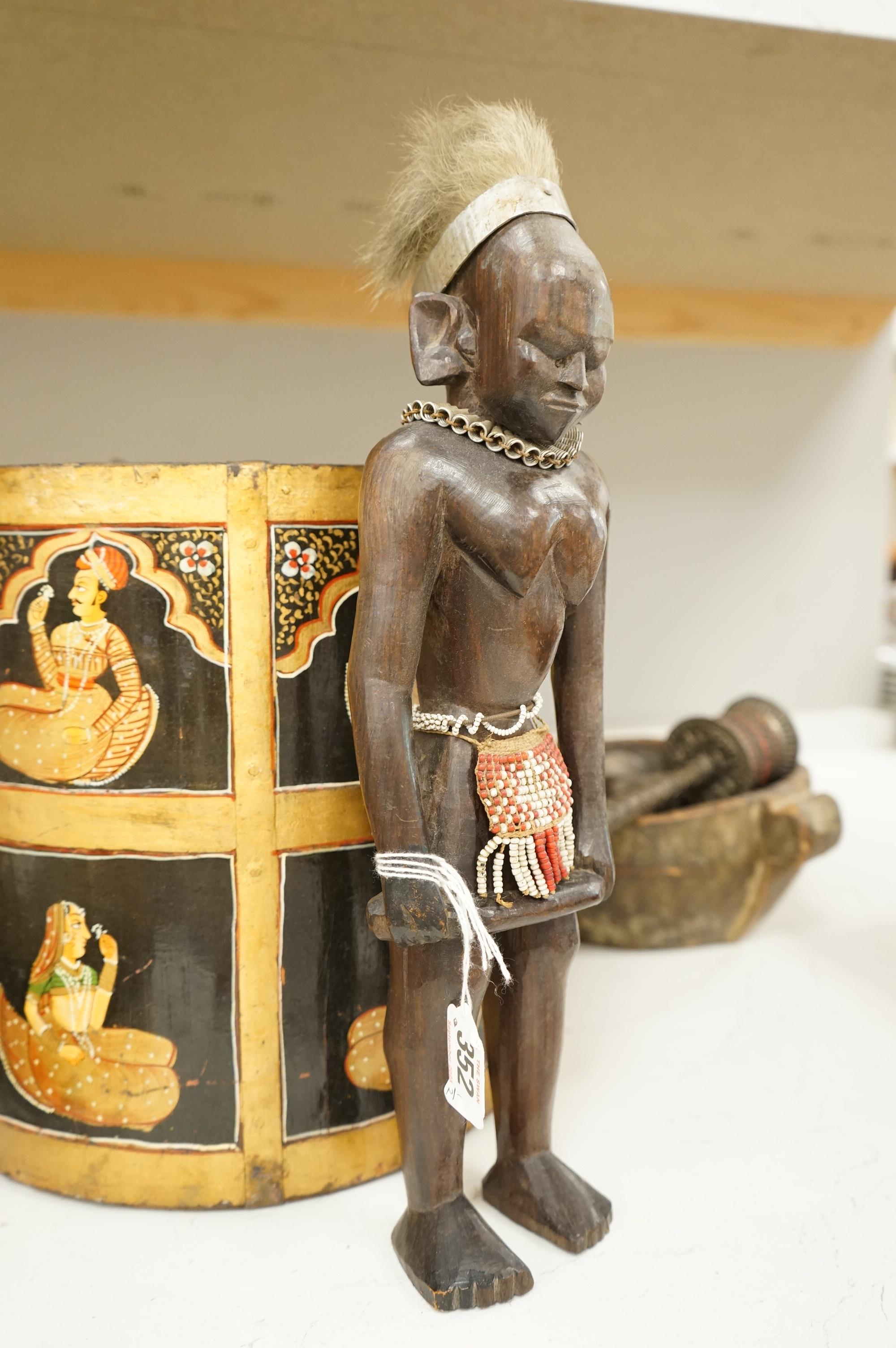 A collection of tribal and Asian collectables including a Tibetan prayer wheel, carvings, etc.
